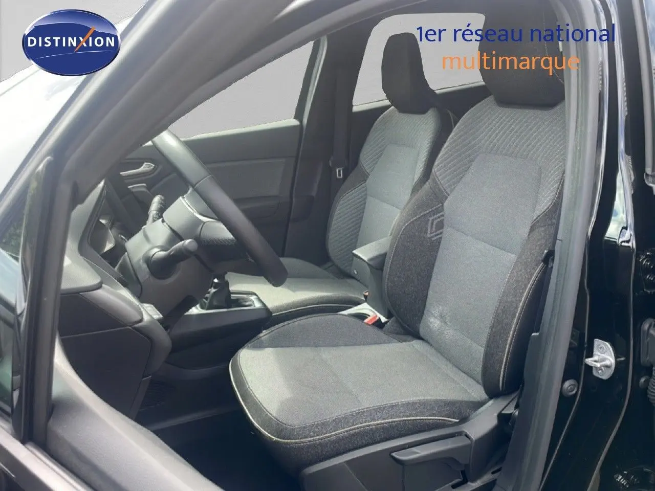 Vue intérieure côté conducteur du Renault Captur 2025 noir étoile métal, sièges tissu gris et volant visible.