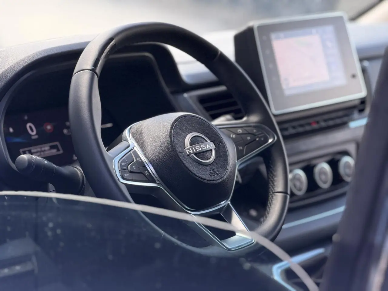 Vue rapprochée du volant noir et du tableau de bord avec écran tactile du Nissan Primastar 2025.