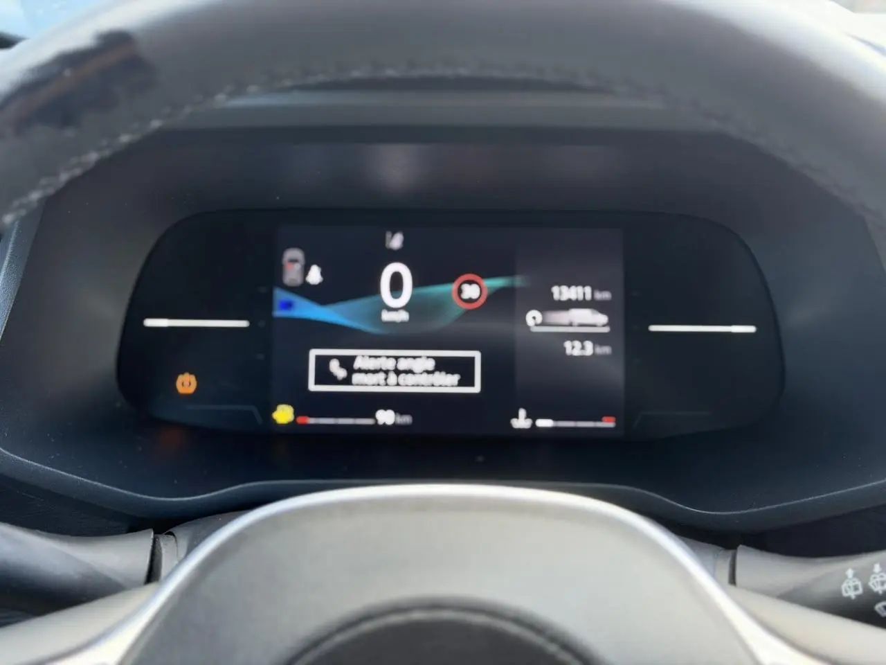 Vue rapprochée du tableau de bord numérique du Nissan Primastar 2025, affichant la vitesse et alertes.
