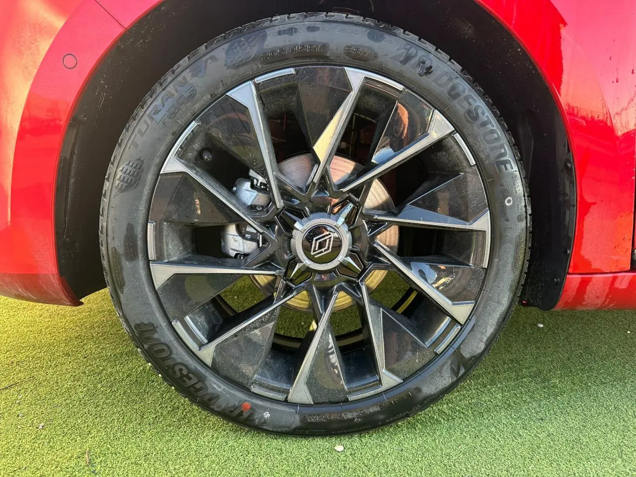 Gros plan sur la jante alliage 17 pouces noire et grise de la Renault Clio rouge foncé, côté arrière droit.