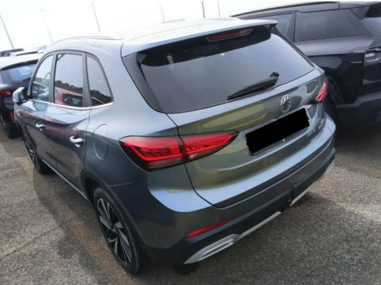 Vue 3/4 arrière droite du MG ZS 1.5 Hybrid+ 197 Luxury gris Hampstead avec feux arrière LED et jantes alliage 18 pouces.