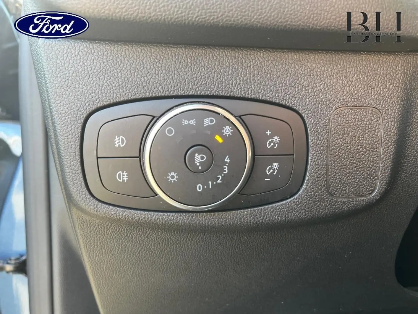 Gros plan sur la commande des phares dans l’habitacle d’une Ford Focus SW 2024 bleu azur métallisé.