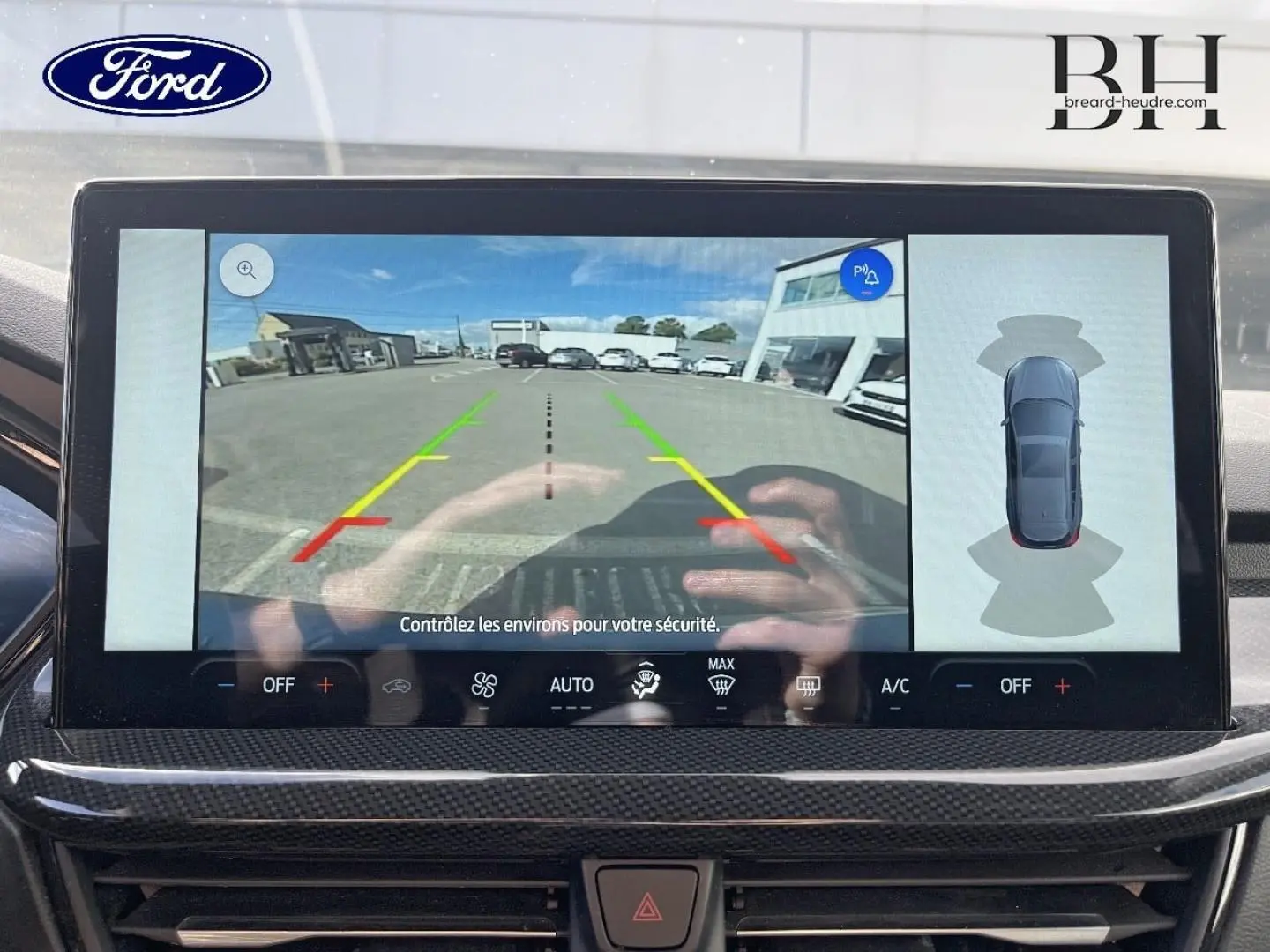 Écran tactile intérieur montrant la caméra de recul et l’aide au stationnement du Ford Focus SW bleu azur 2024.