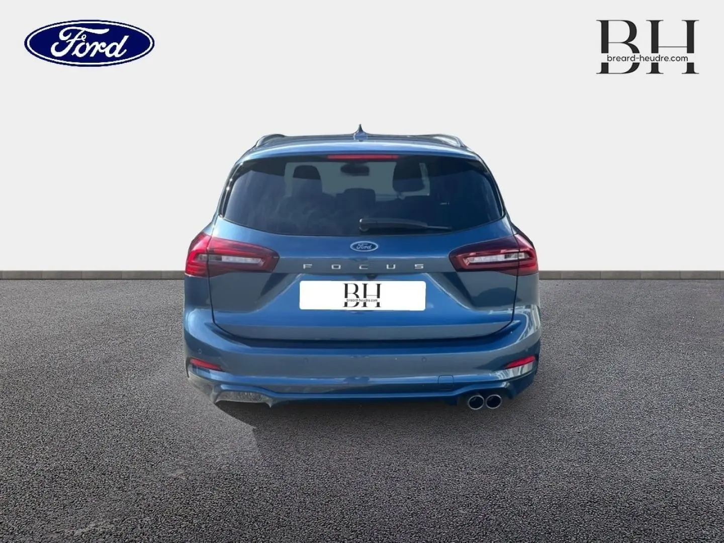 Vue arrière d'une Ford Focus SW 2024 bleu azur métallisé avec double sortie d'échappement chromée et feux LED.
