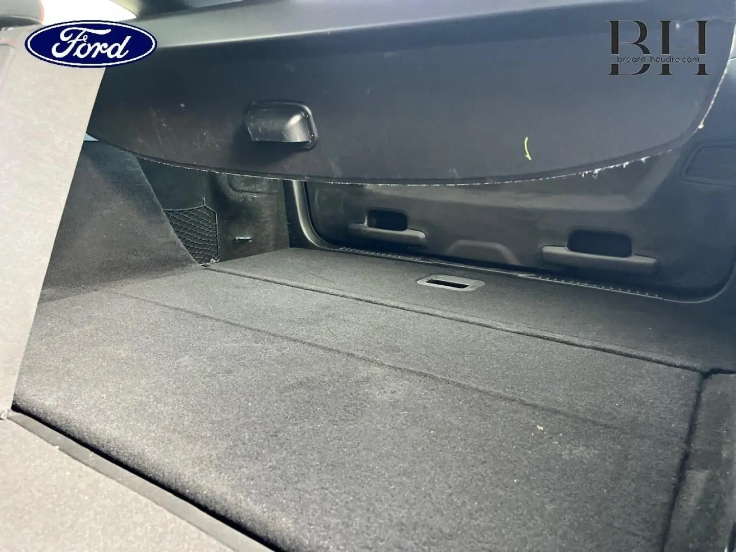 Vue intérieure du coffre spacieux et plat de la Ford Focus SW 2024 en tissu noir, sans chargement visible.