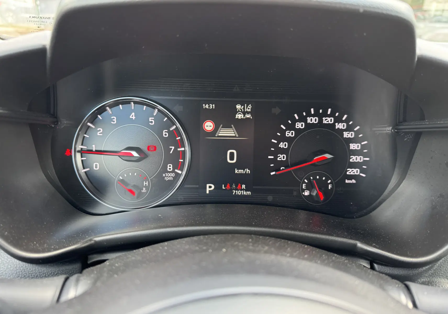 Vue rapprochée du tableau de bord numérique de la Suzuki Swift 1.2 Hybrid Privilege Auto MY24 affichant 0 km/h et 7101 km au compteur.