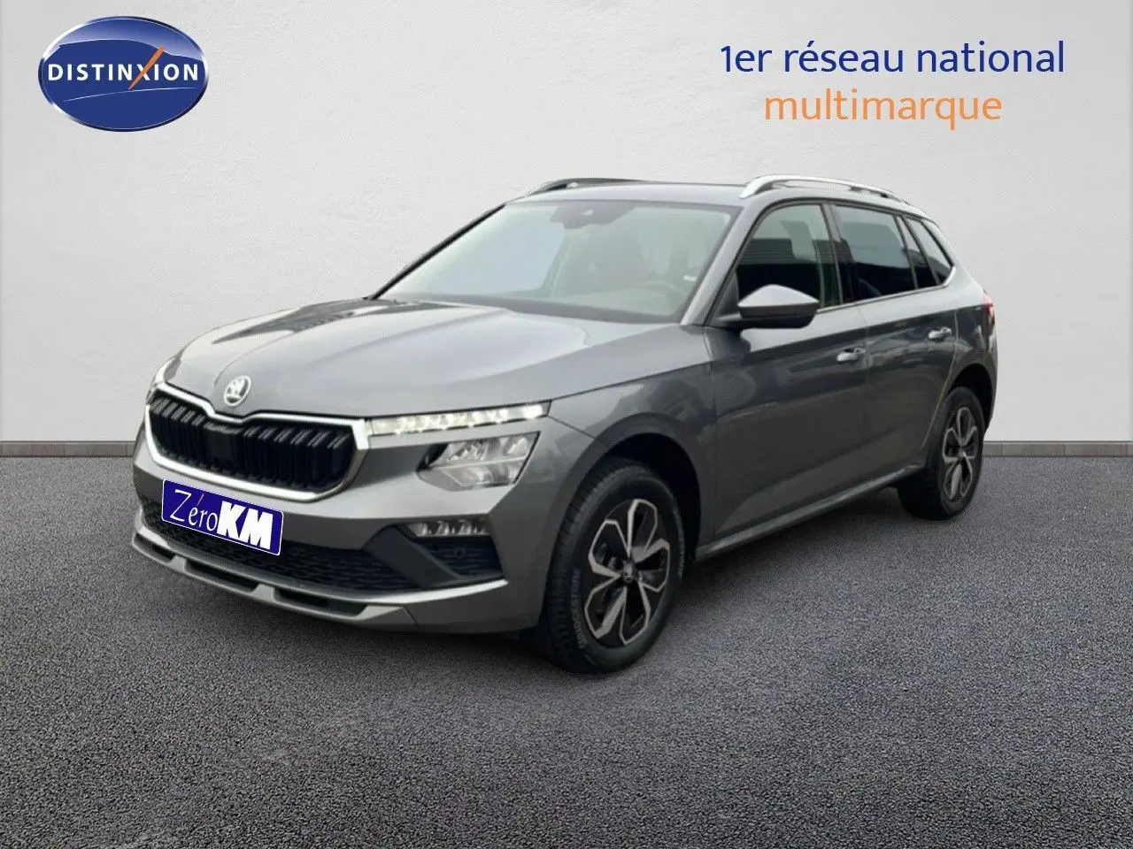 SUV SKODA KAMIQ gris graphite métal vu en 3/4 avant droit avec jantes bi-ton et calandre noire.