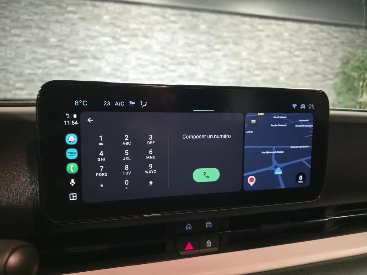 Écran tactile central affichant un clavier de numérotation et une carte GPS dans l'habitacle d'une Fiat 600 bleu.