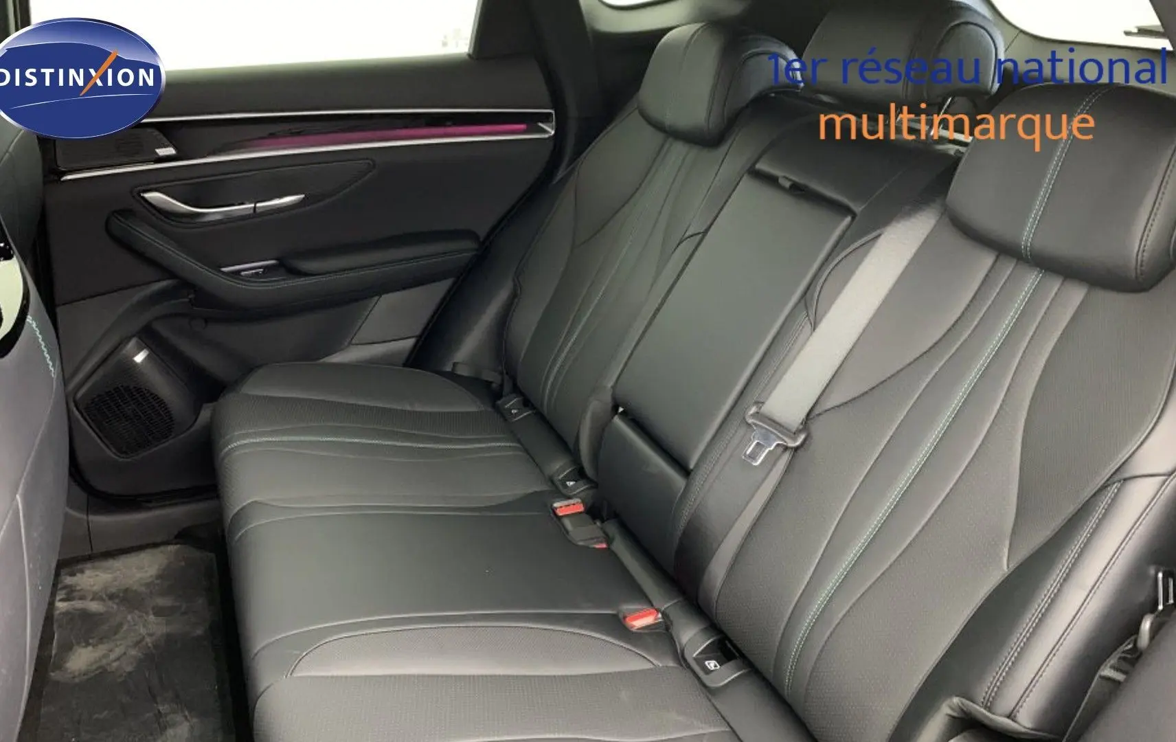 Vue intérieure des sièges arrière en similicuir noir du BYD SEAL U 2025, avec éclairage d'ambiance violet sur la porte.