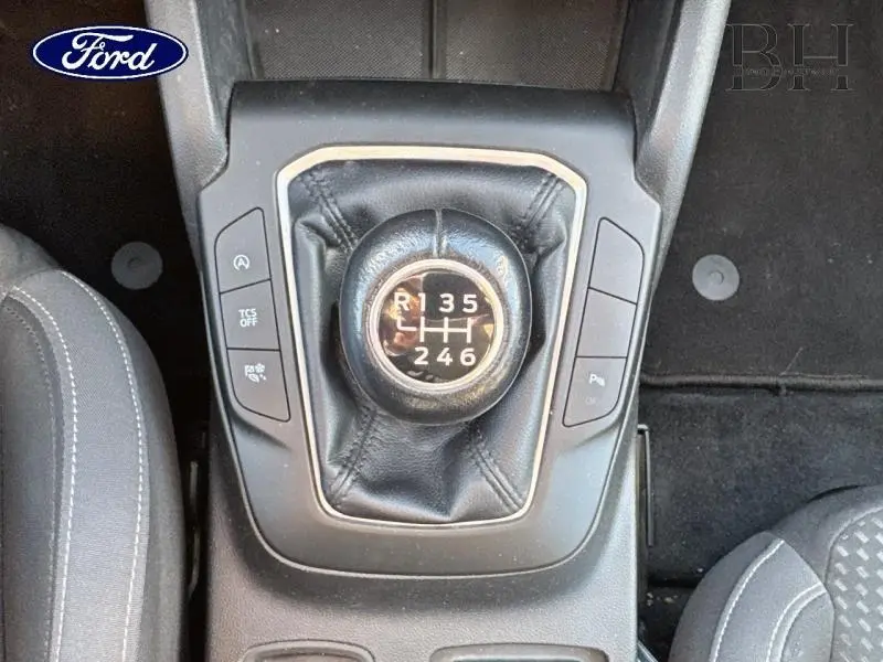 Gros plan sur le levier de vitesses manuel noir de la Ford Focus gris lunaire, entouré de boutons de commande.