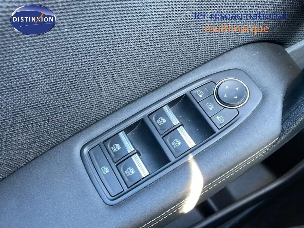 Gros plan sur la commande des vitres électriques côté gauche d’un Renault Symbioz noir étoile métal, intérieur tissu noir.