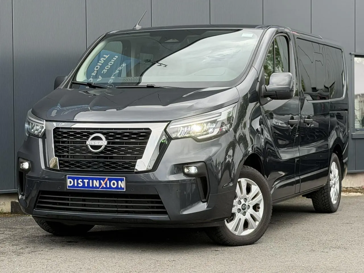 Vue 3/4 avant d’un Nissan Primastar Combi gris comète avec hayon vitré et jantes alliage 17 pouces.