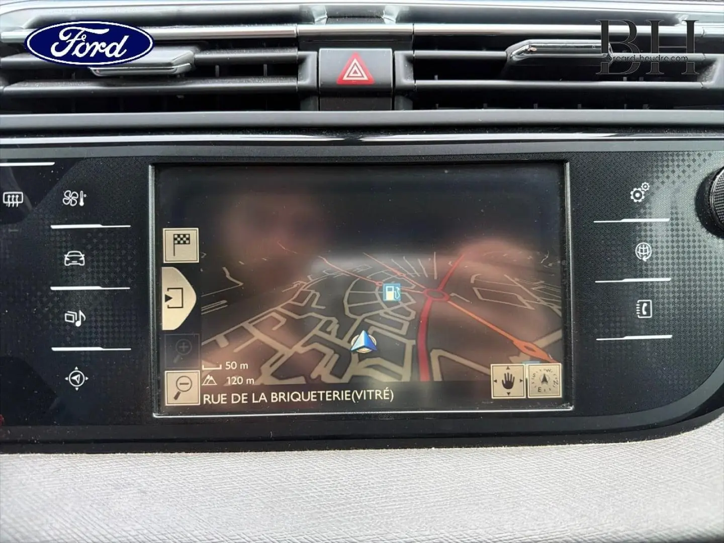 Écran tactile de navigation GPS Ford en gros plan avec carte affichant Rue de la Briqueterie, intérieur noir.
