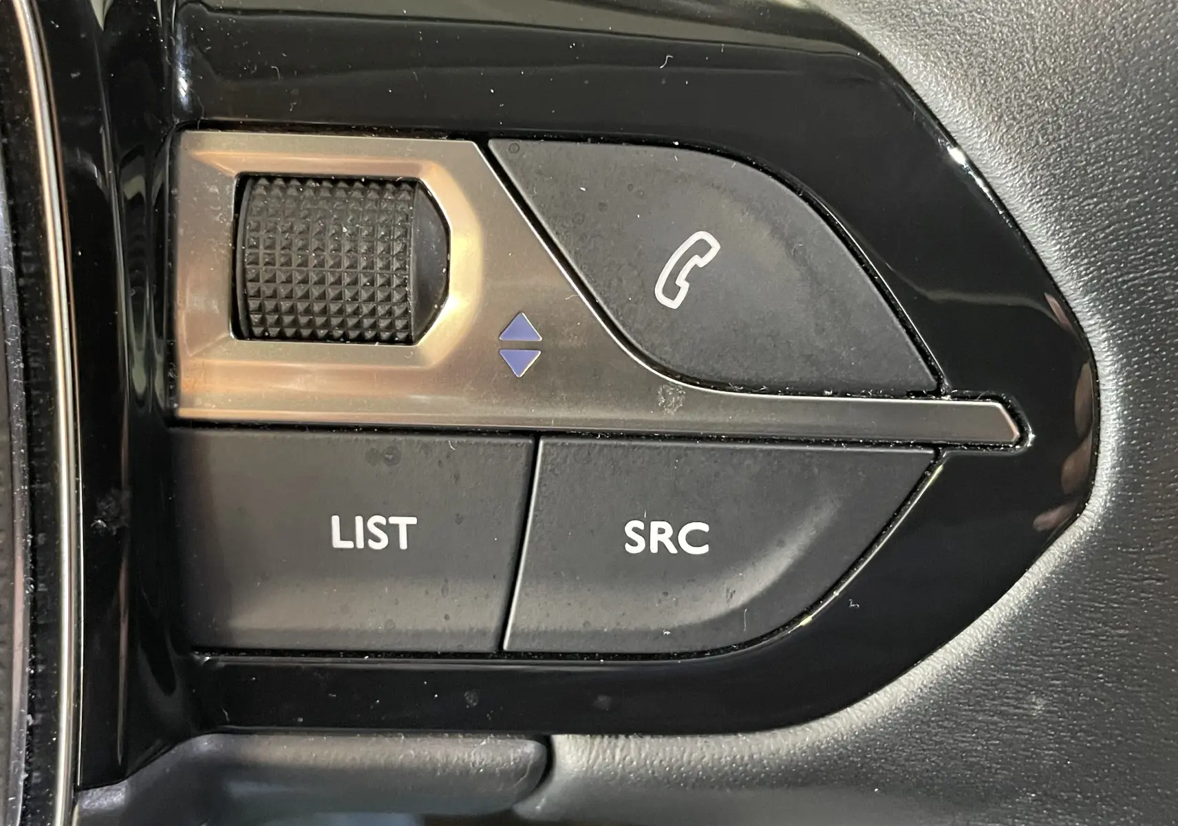Gros plan sur les commandes noires du volant Peugeot 508 2021, boutons LIST, SRC et téléphone visible.