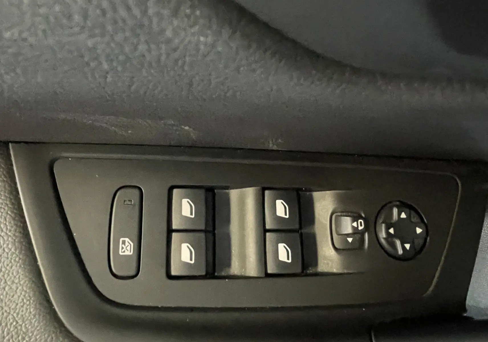 Panneau de commandes des vitres électriques et réglage des rétroviseurs côté conducteur d'une Peugeot 508 gris platinium.