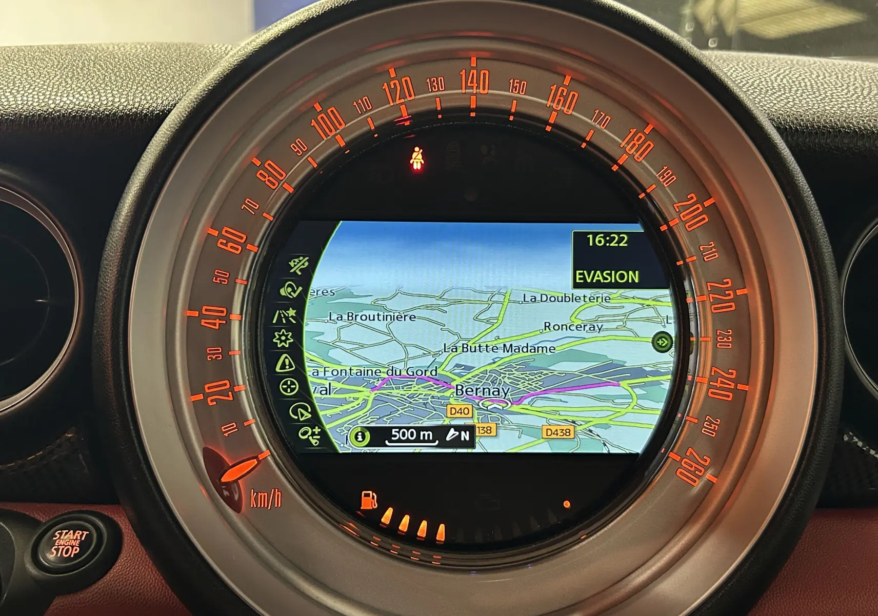 Vue rapprochée du tableau de bord du MINI Cabriolet rouge, mettant en valeur l'écran central du système radio FM.