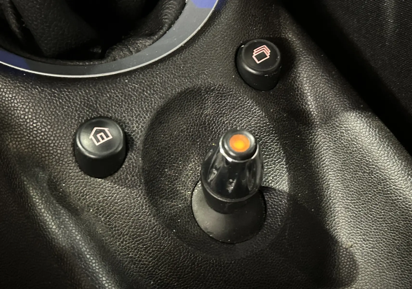 Gros plan sur les commandes de régulateur de vitesse sur le volant en cuir noir d'une MINI Cabriolet rouge 2012.