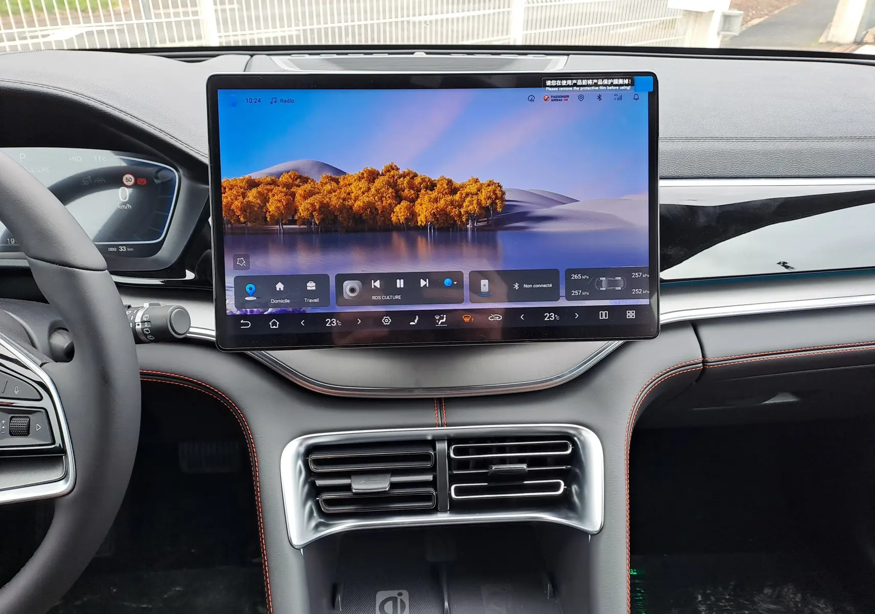 Vue intérieure frontale du tableau de bord BYD SEAL U 2025 avec écran tactile central 15,6'' et finitions noires avec surpiqûres orange.