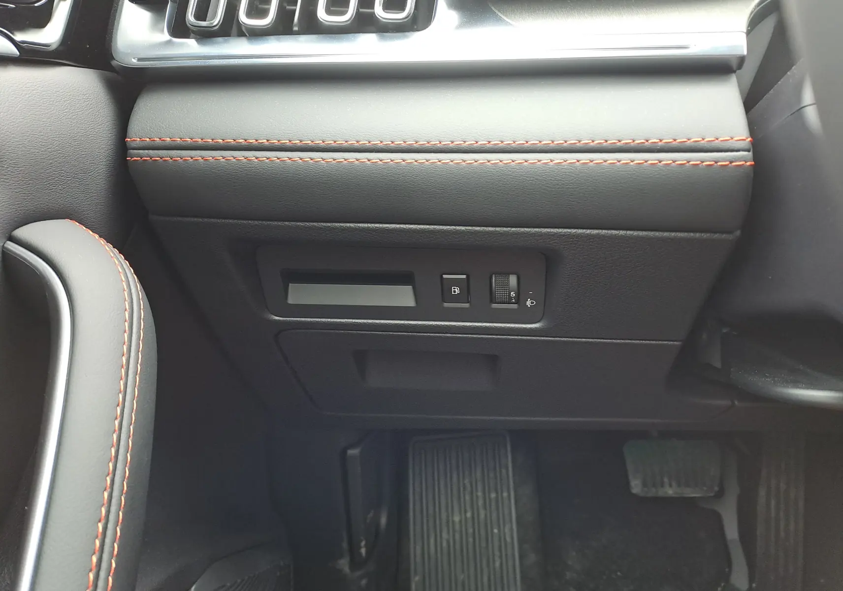 Détail intérieur côté conducteur du tableau de bord noir avec surpiqûres rouges et commandes sous volant du BYD SEAL U.