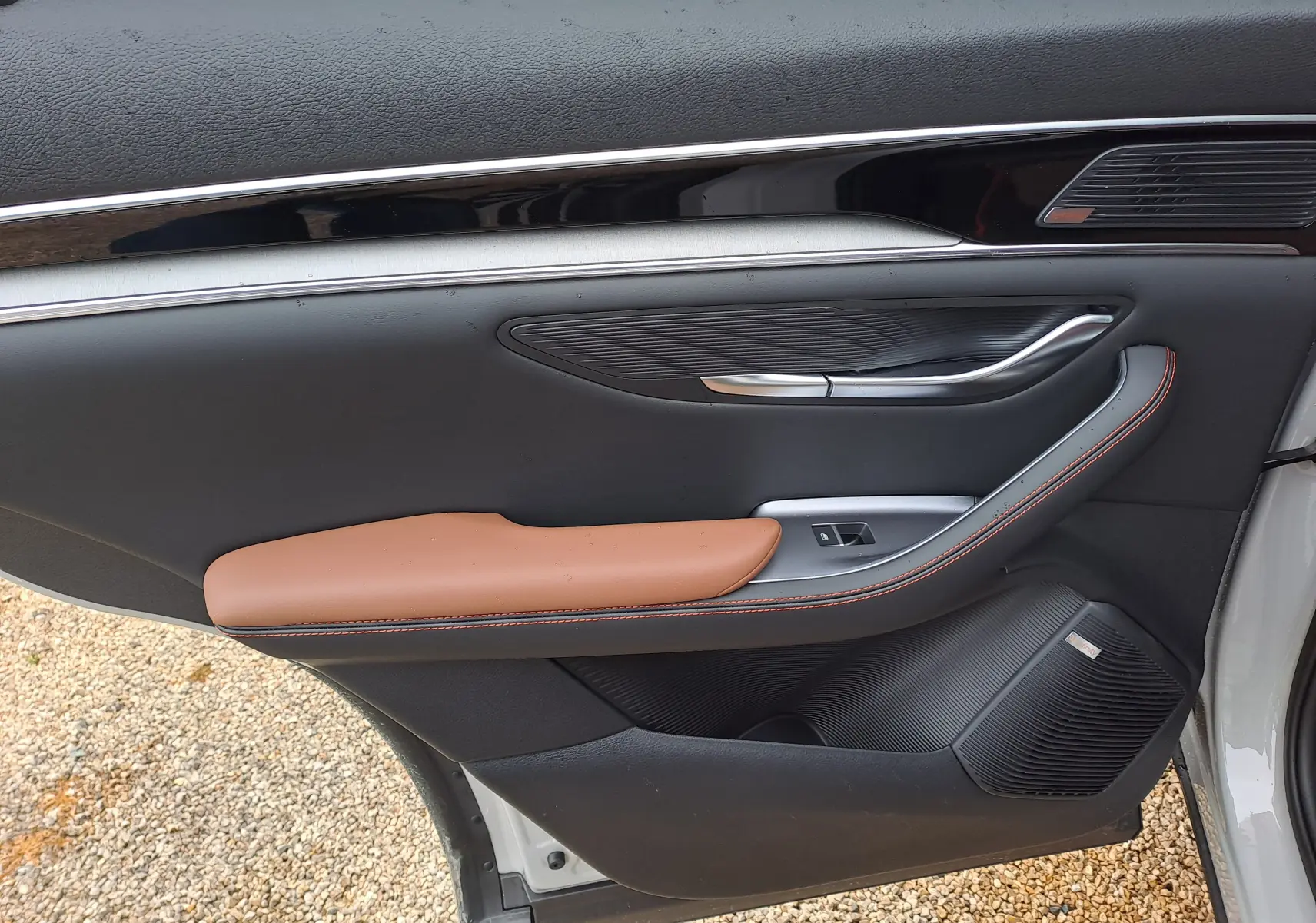 Vue côté gauche de la porte avant d’une BYD SEAL U 2025 BOUNDLESS CLOUD, avec accoudoir marron et détails noirs.