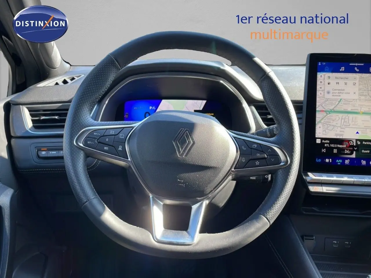 Vue intérieure centrée sur le volant noir perforé du Renault Symbioz 2025 avec tableau de bord numérique et écran tactile GPS.