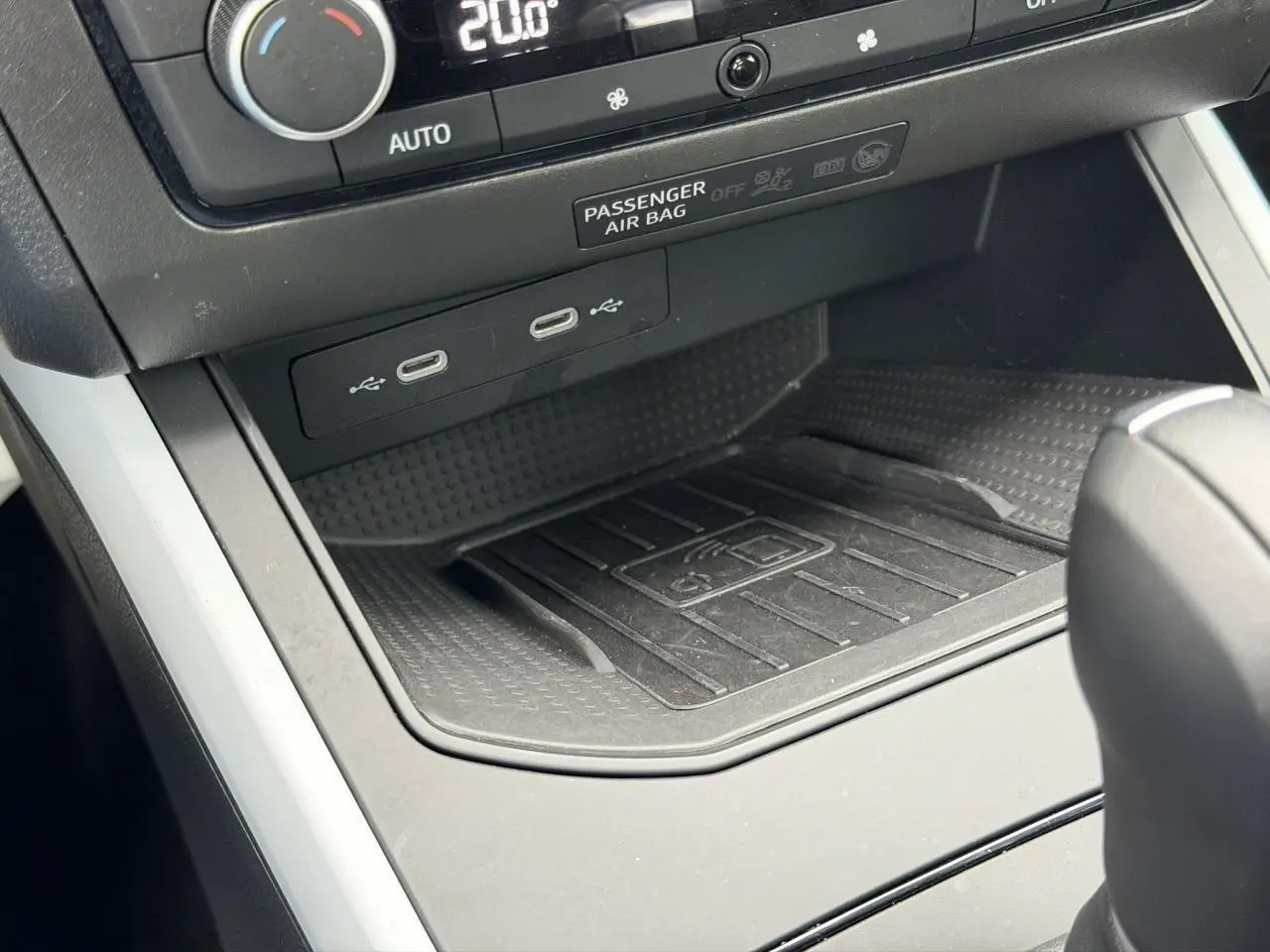 Gros plan sur la console centrale du SEAT Arona blanc, montrant la zone de recharge sans fil et ports USB-C.