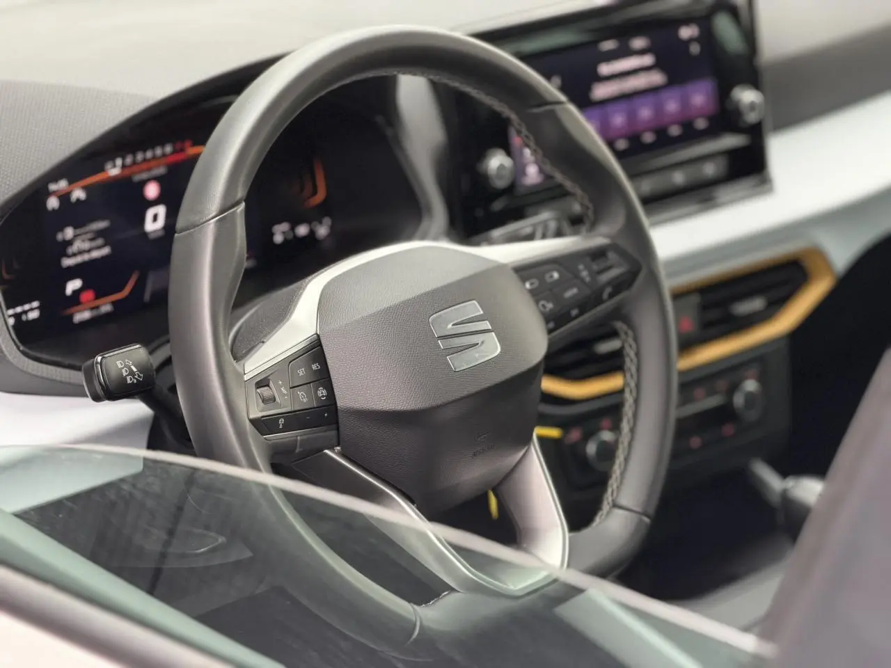 Vue rapprochée du volant noir et du tableau de bord digital du SEAT Arona TSI 115 DSG Style 2025, intérieur moderne.