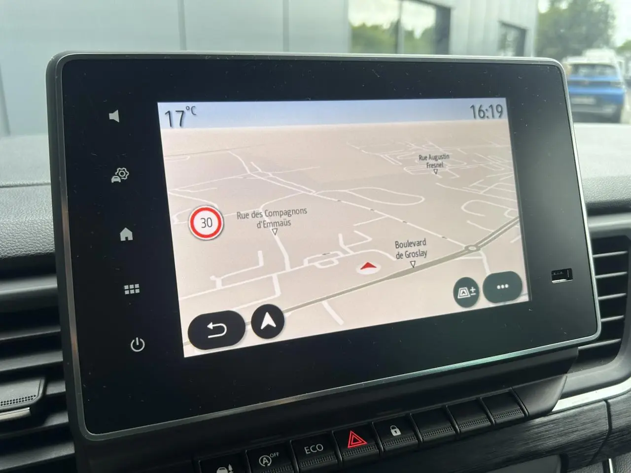 Écran tactile central affichant la navigation GPS dans l'habitacle du Nissan Primastar gris Highland, vue de face rapprochée.