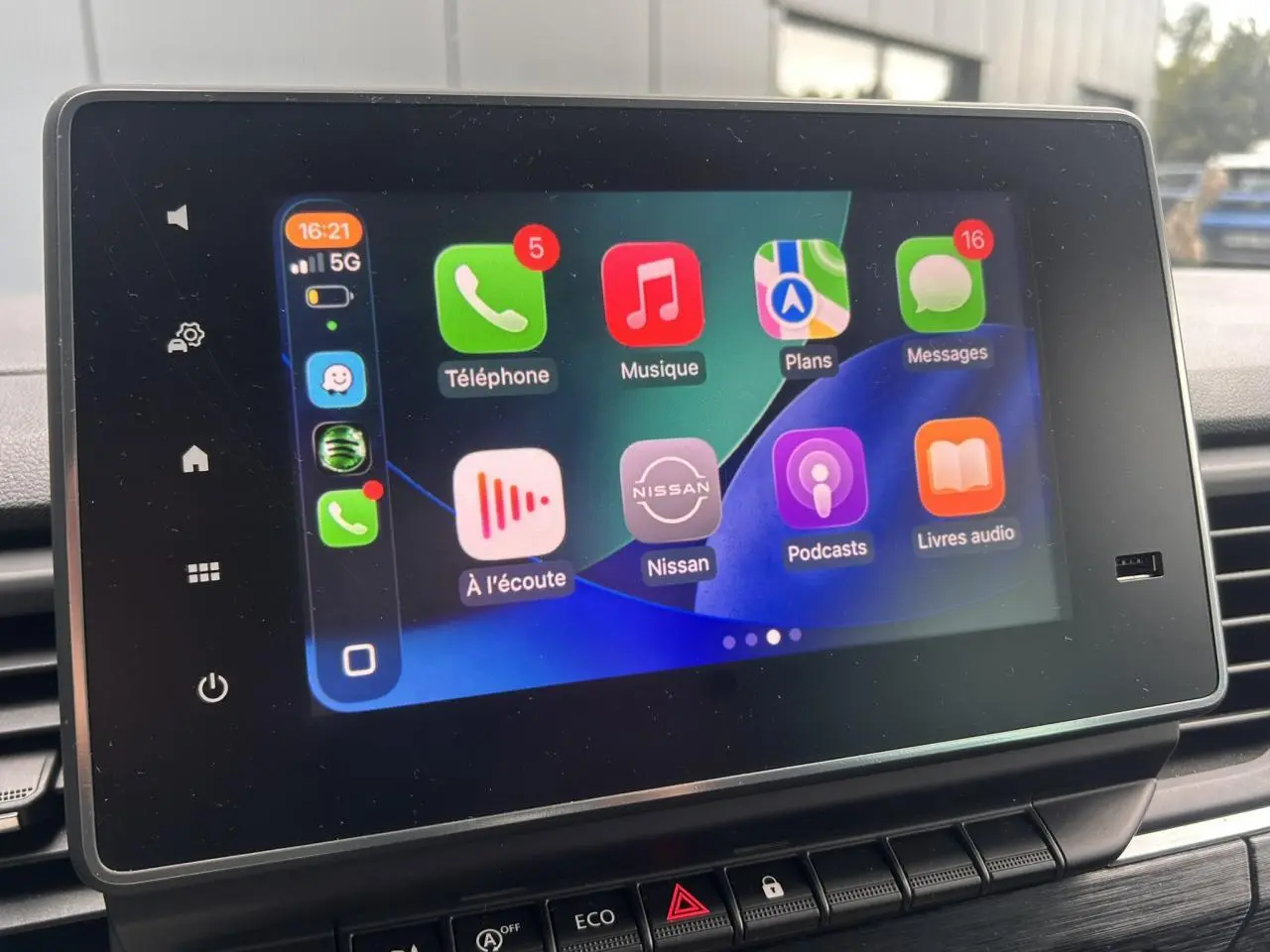 Écran tactile central affichant l'interface Apple CarPlay dans l'habitacle d'un Nissan Primastar gris Highland.