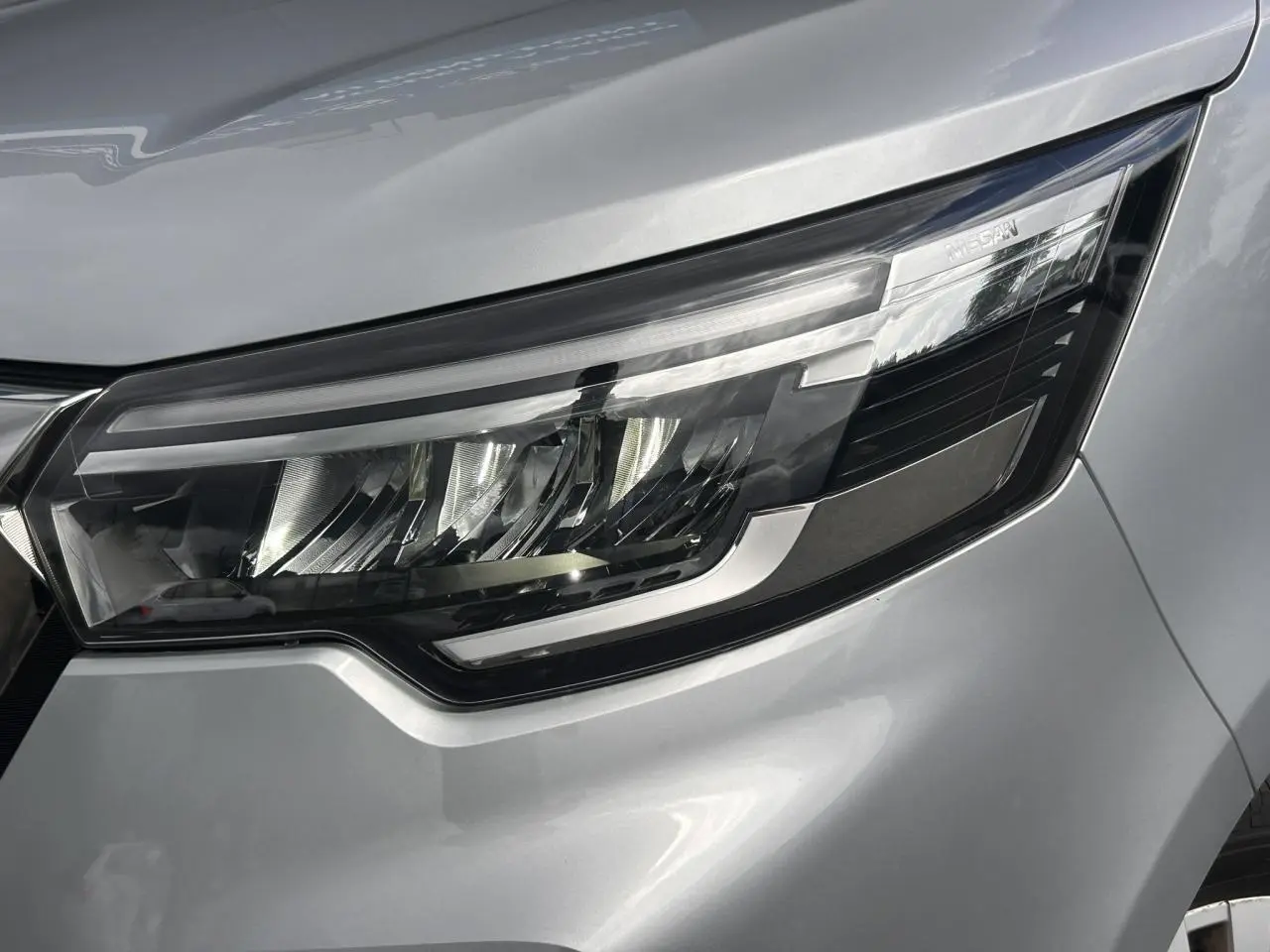 Gros plan sur le phare avant droit du Nissan Primastar gris Highland, mettant en valeur son design LED moderne.