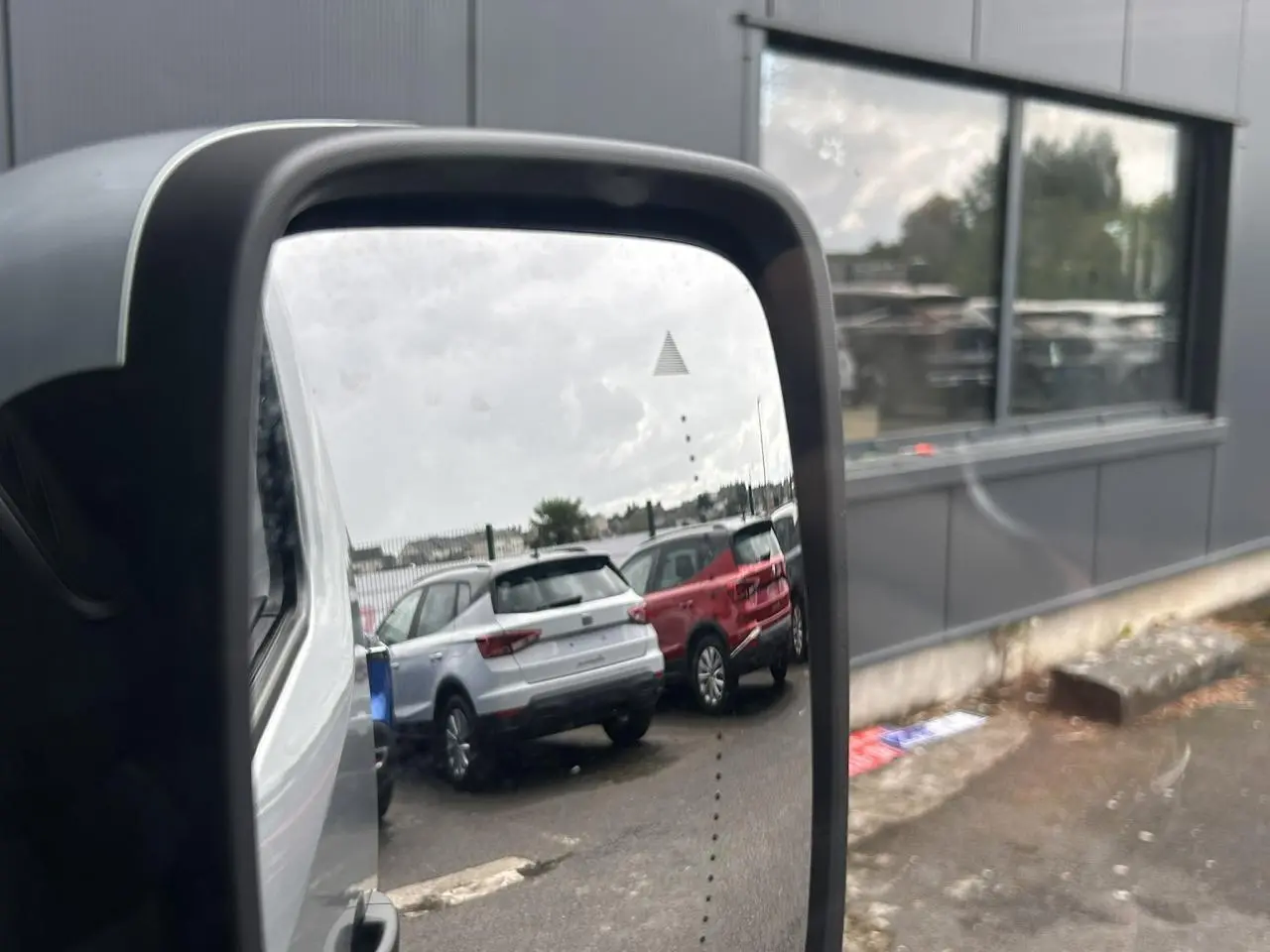 Rétroviseur extérieur droit d’un Nissan Primastar gris Highland, avec affichage d’alerte d’angle mort visible.