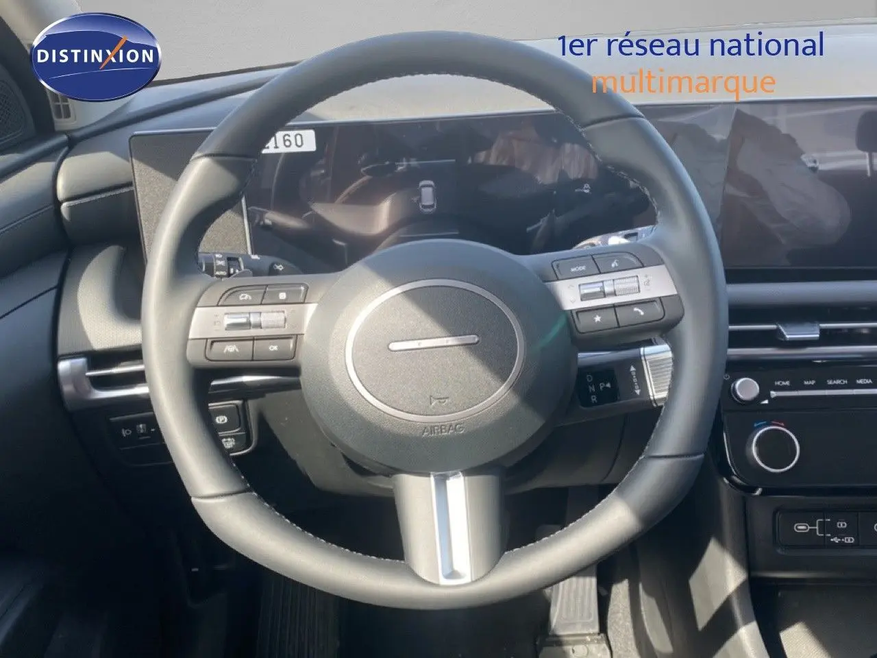 Vue centrée sur le volant cuir multifonction du Hyundai Tucson 2026 gris Ecotronic, avec tableau de bord digital et écran tactile.