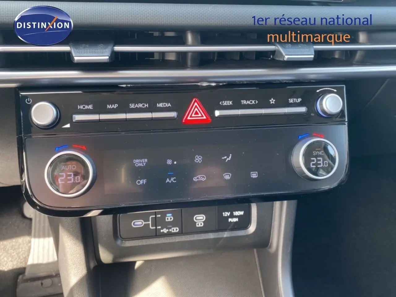 Vue rapprochée de la console centrale du Hyundai Tucson gris Ecotronic, affichant la climatisation digitale à 23°C.