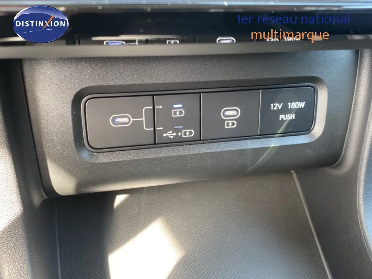 Gros plan sur les ports USB et prise 12V du Hyundai Tucson gris Ecotronic Metal, intérieur noir.