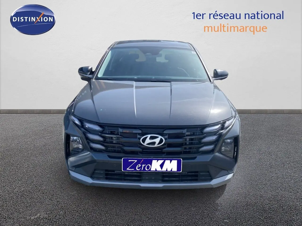 Vue frontale d'un Hyundai Tucson gris Ecotronic Metal avec calandre noire et phares LED intégrés.
