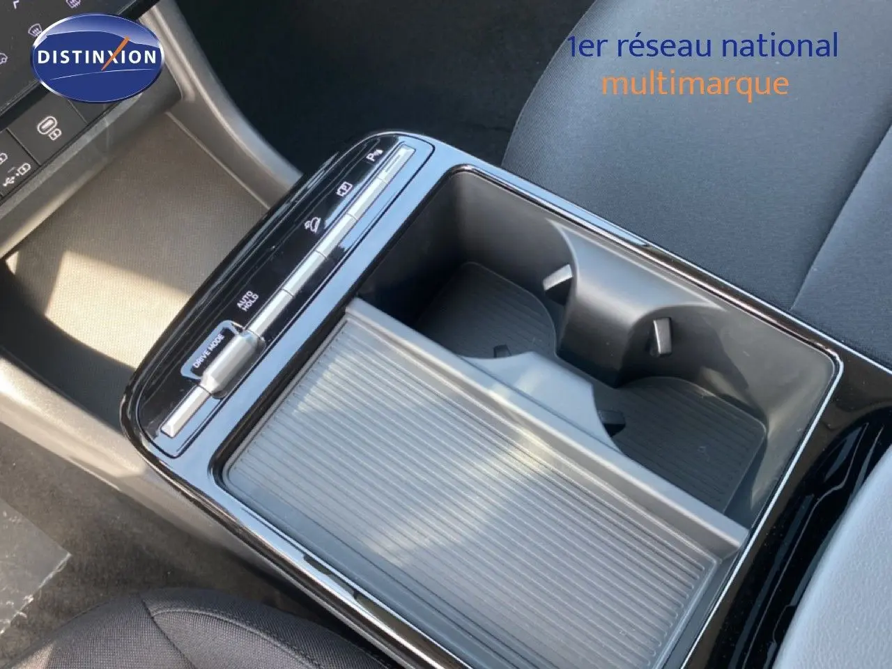 Gros plan sur la console centrale noire du Hyundai Tucson 2026, montrant les porte-gobelets et commandes de boîte auto.