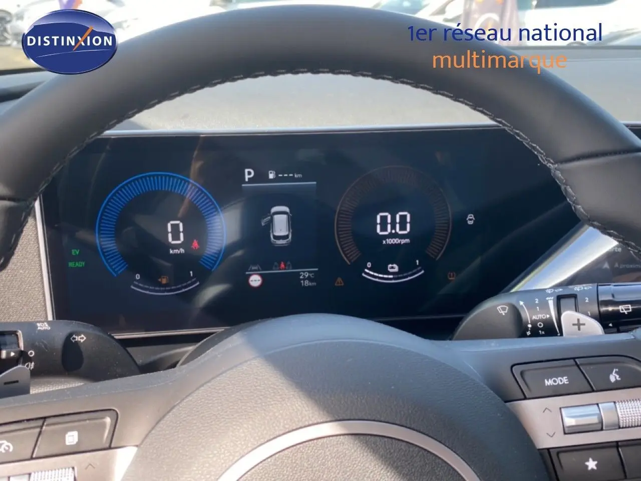 Vue rapprochée du tableau de bord numérique et volant cuir noir du Hyundai Tucson gris Ecotronic 2026 hybride essence.