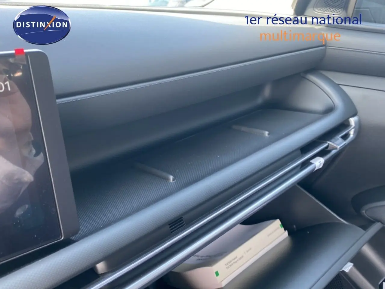 Intérieur du Hyundai Tucson 2026, vue latérale du tableau de bord et rangement ouvert en finition noire moderne.