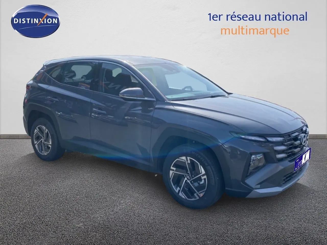 Vue 3/4 avant droite du Hyundai Tucson gris Ecotronic Metal avec jantes alliage et calandre marquée.
