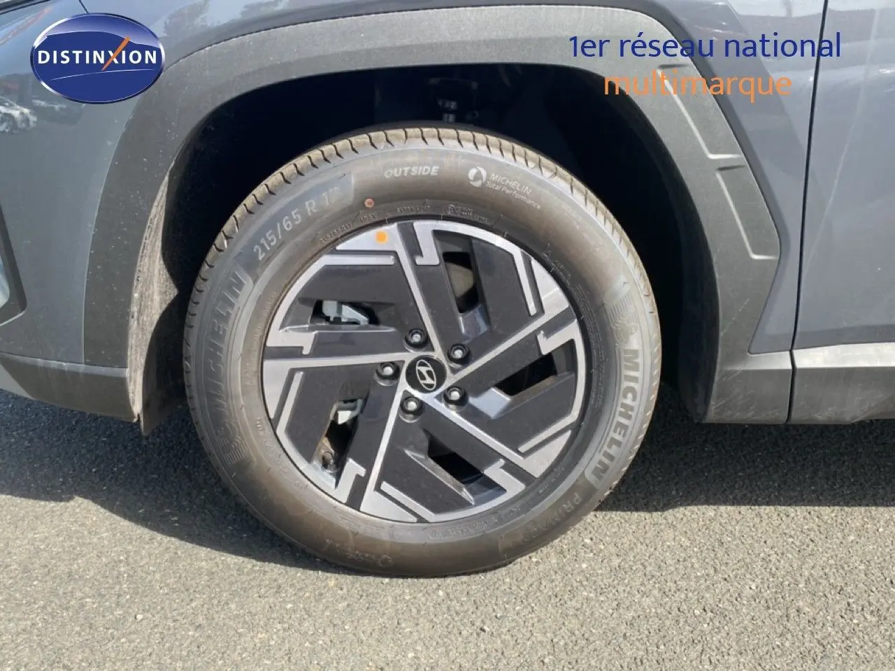 Gros plan sur la roue avant droite du Hyundai Tucson gris Ecotronic Metal avec jante alliage au design moderne.