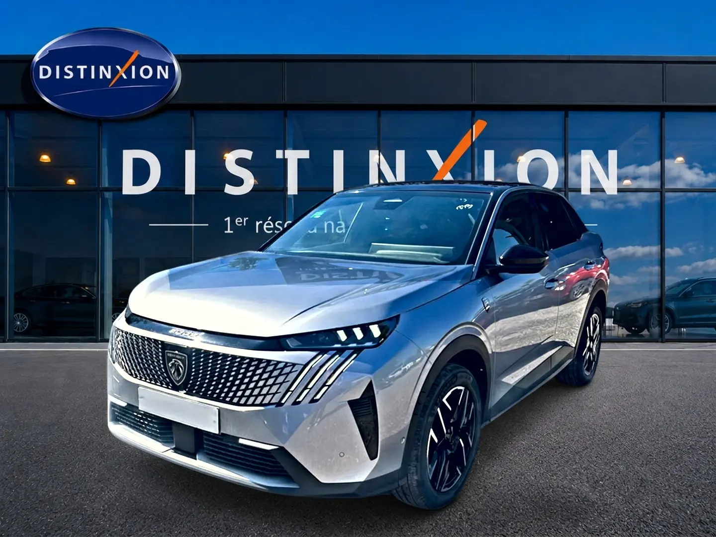Peugeot 3008 gris 3/4 avant droit, avec calandre distinctive et phares LED, devant une vitrine Distinxion.