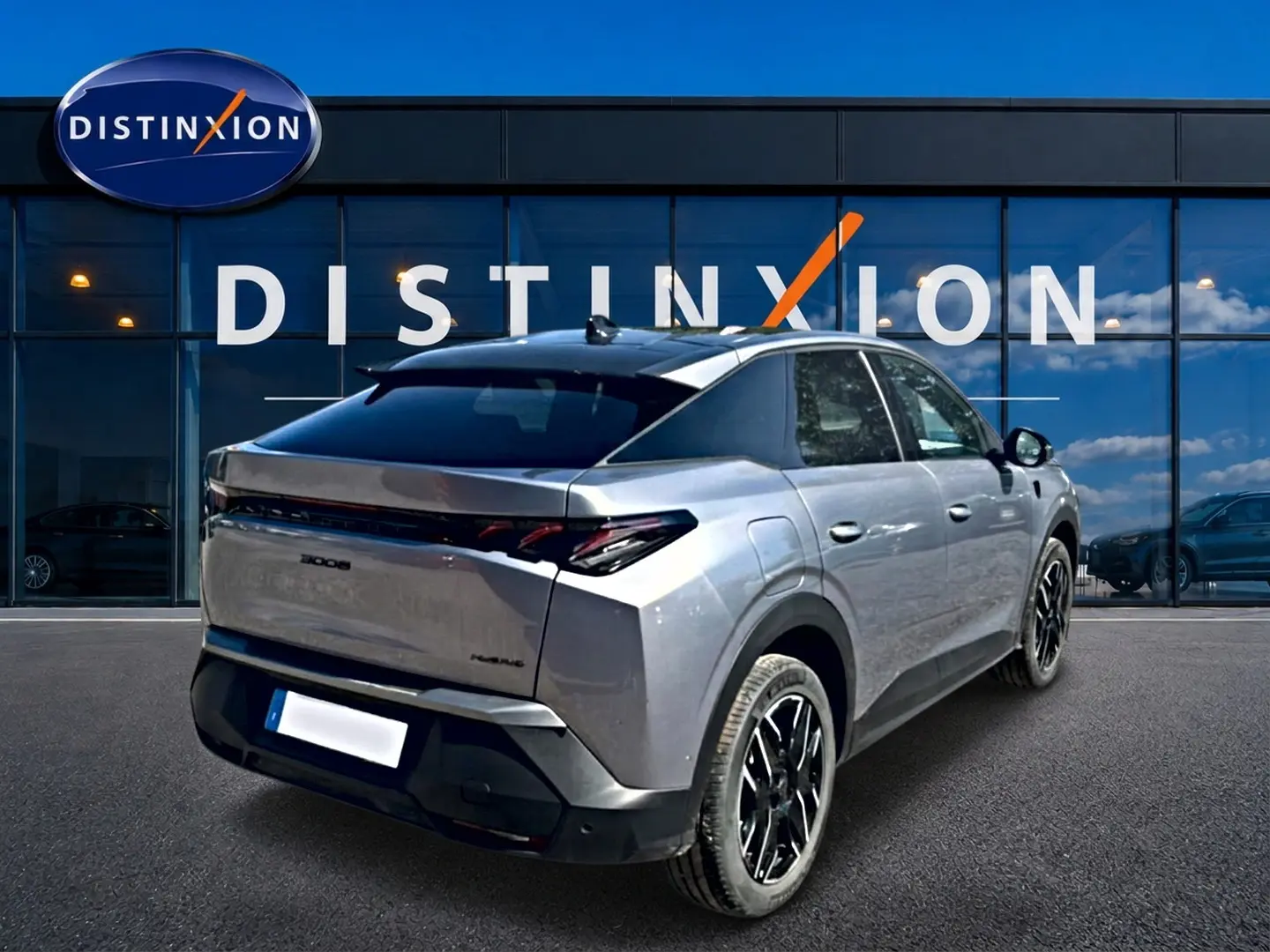 Vue 3/4 arrière droite du Peugeot 3008 gris 2025 avec toit noir et jantes alliage noires devant une vitrine Distinxion.