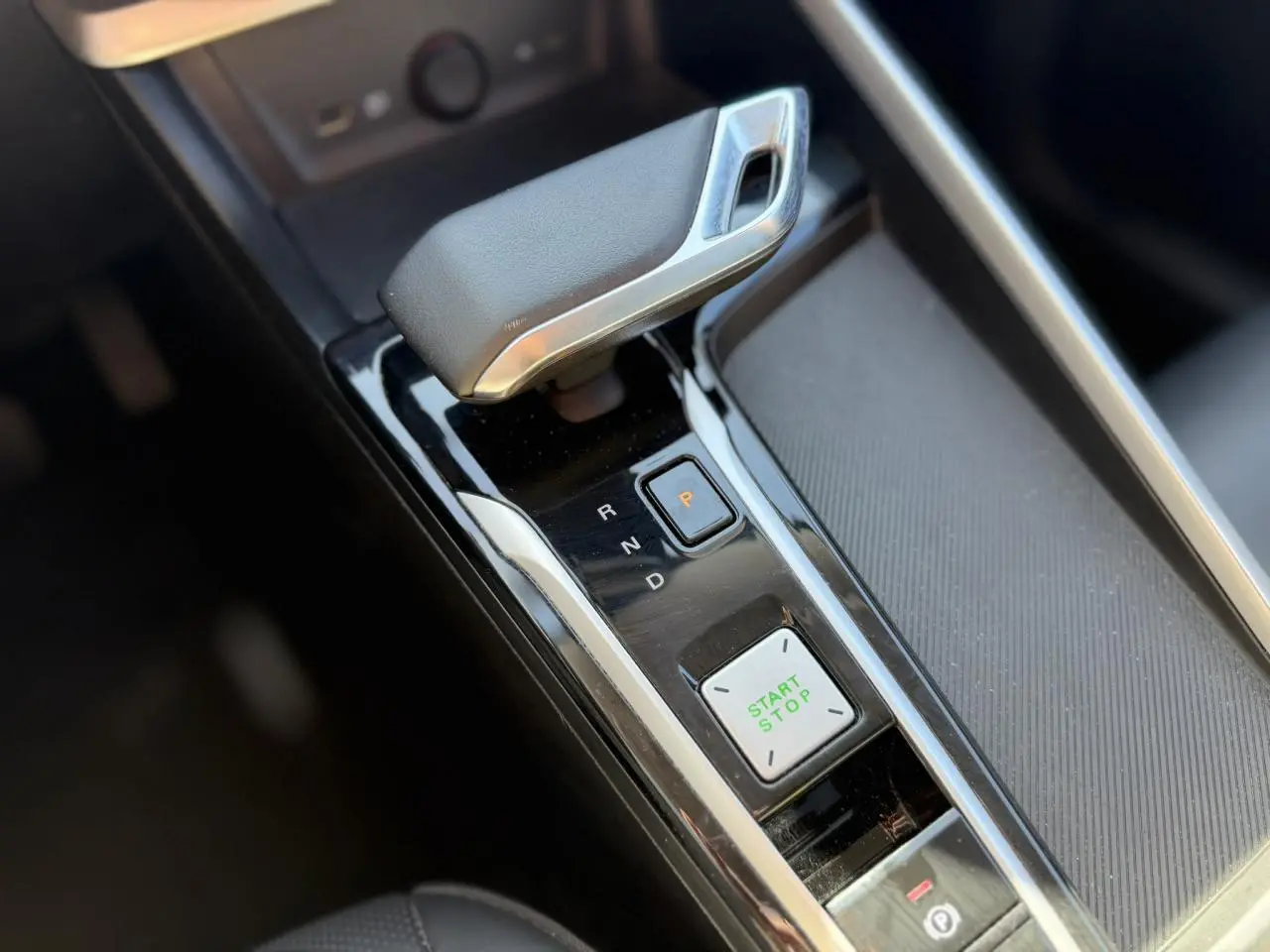 Gros plan sur la commande de boîte automatique et bouton start/stop dans l’habitacle noir du MG ZS 1.5 Hybrid+ 197 Luxury.
