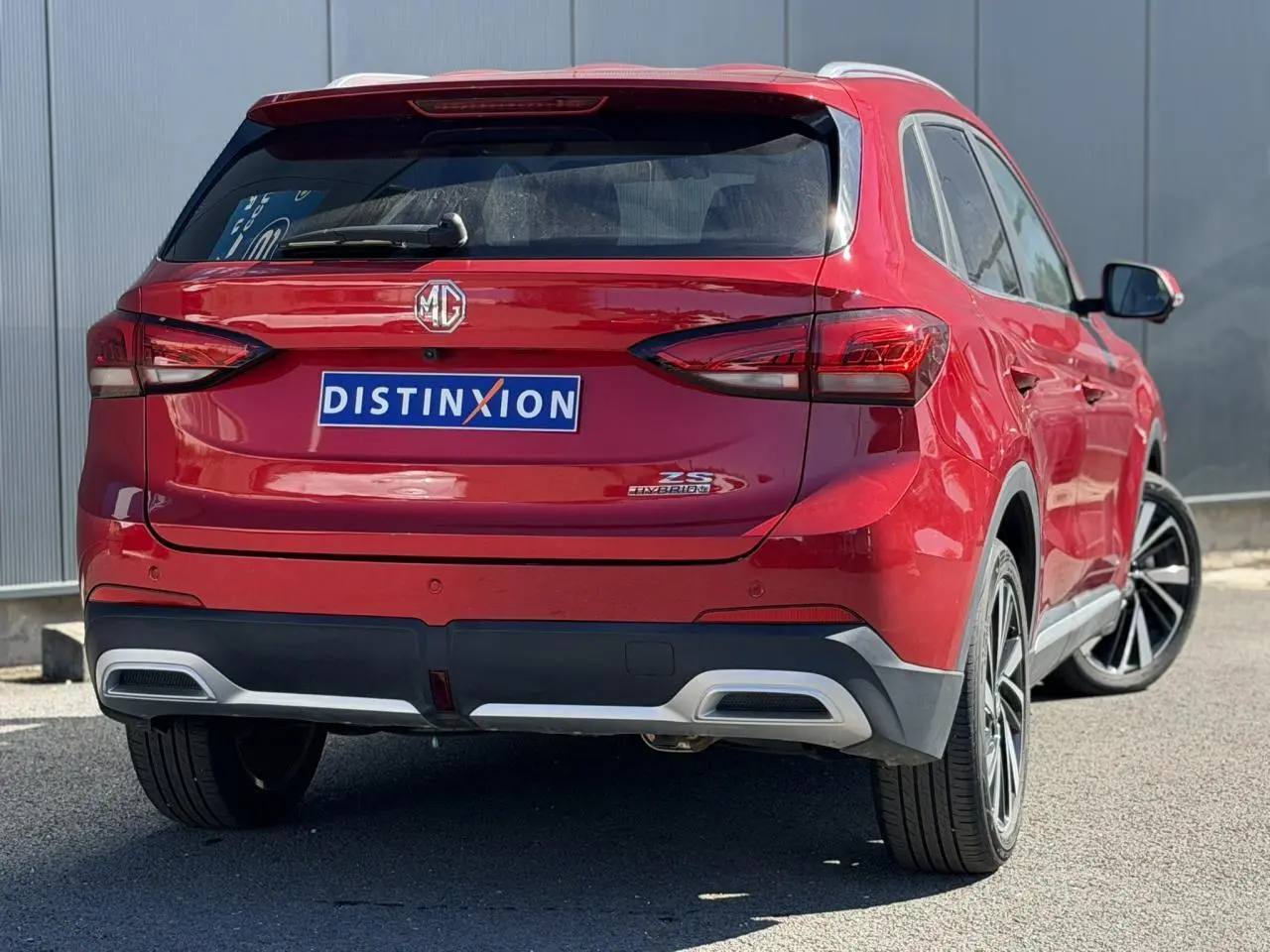 Vue 3/4 arrière droite du SUV MG ZS 1.5 Hybrid+ 197 Luxury en rouge Diamond avec jantes alliage 18 pouces.
