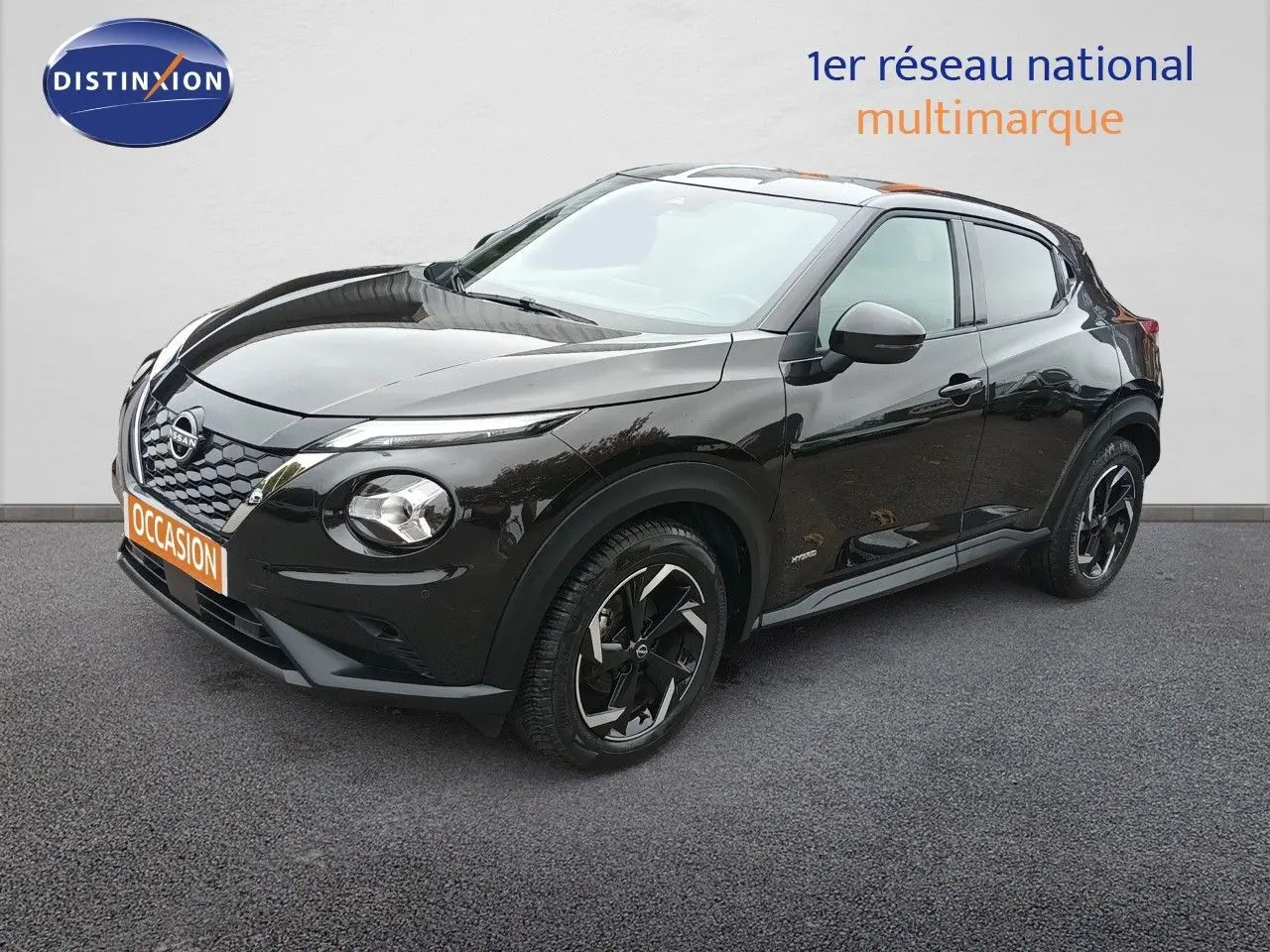Nissan Juke Hybrid noir métal en 3/4 avant droit, avec jantes noires et détails modernes visibles.