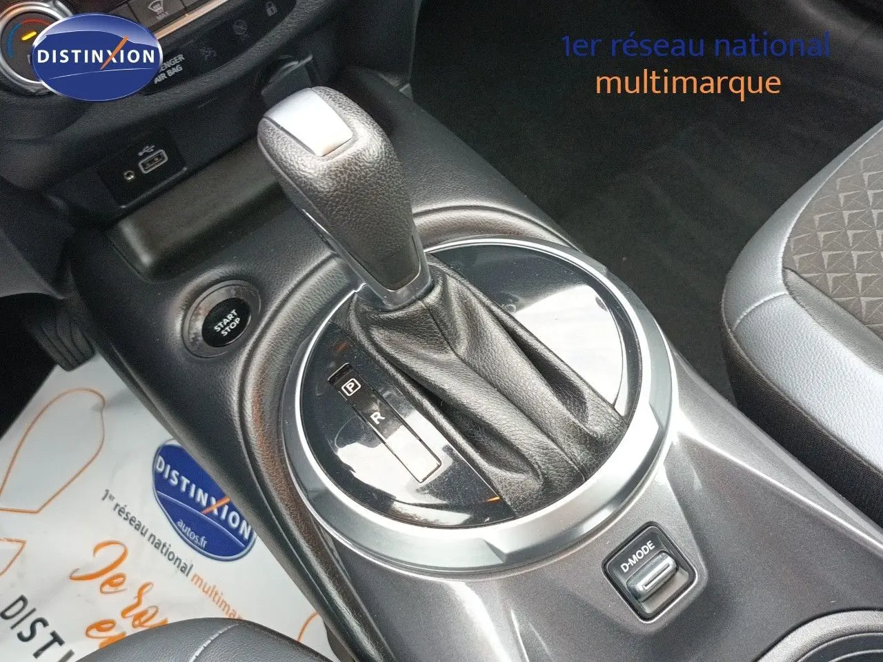 Gros plan sur le levier de vitesses automatique du Nissan Juke Hybrid noir métal, avec bouton D-Mode visible.