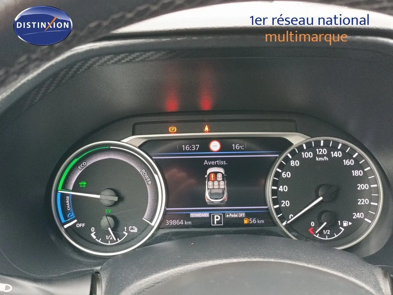 Vue rapprochée du tableau de bord du Nissan Juke Hybrid noir, affichant les compteurs et l'écran digital central.