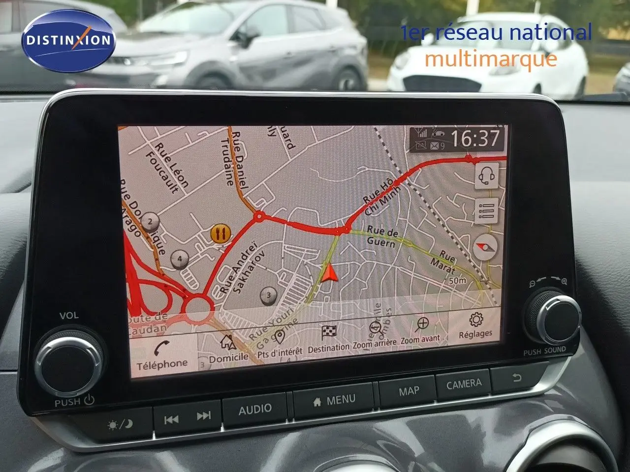 Vue intérieure sur l’écran tactile du GPS du Nissan Juke Hybrid 2024 noir métal, affichant une carte routière détaillée.