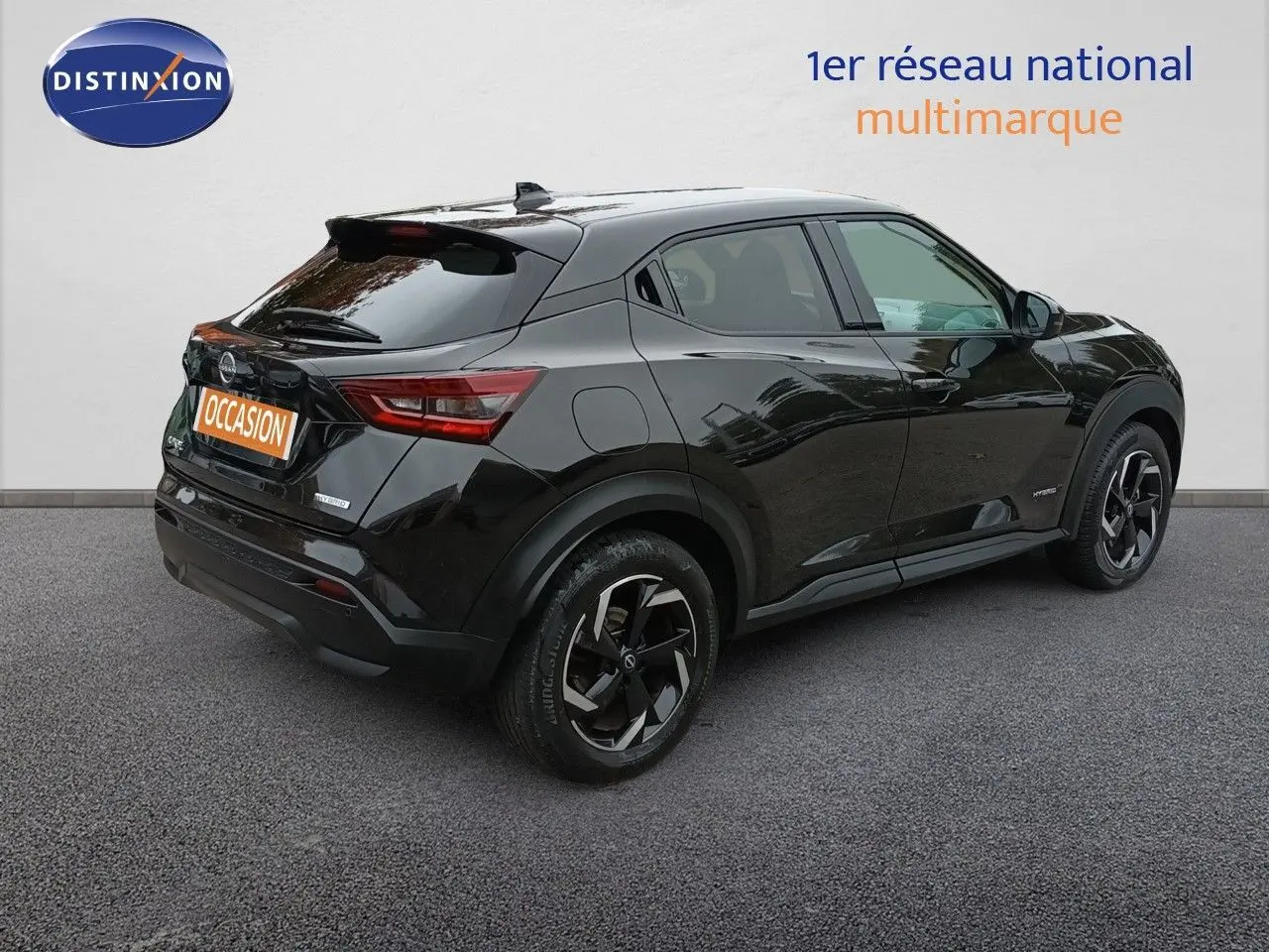 Vue 3/4 arrière droite du Nissan Juke Hybrid 143ch Business+ noir métal avec jantes bi-ton et feux LED distinctifs.