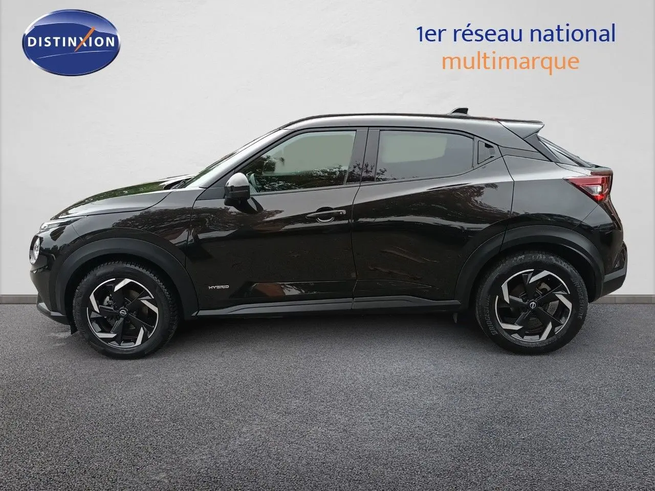 Profil côté gauche d'un Nissan Juke Hybrid 143ch Business+ noir métal avec jantes alliage bicolores, 2024.
